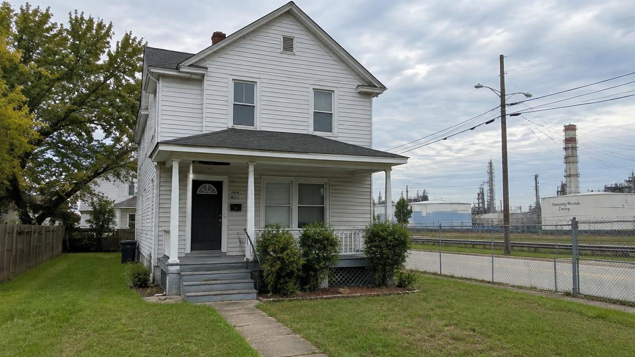 Older two story frame house near an industrial corridor in Armistead, Hampton, Virginia