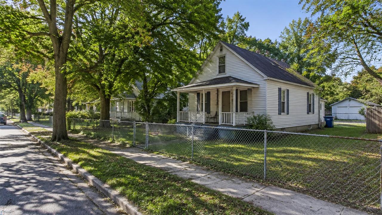 Modest older home along a tree lined boulevard with a chain link fence in Battlefield Park, Chesapeake, Virginia
