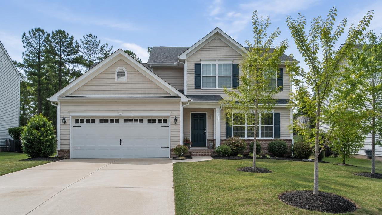 2000s traditional suburban home with a two-car garage and young trees in Edinburgh, Chesapeake, Virginia