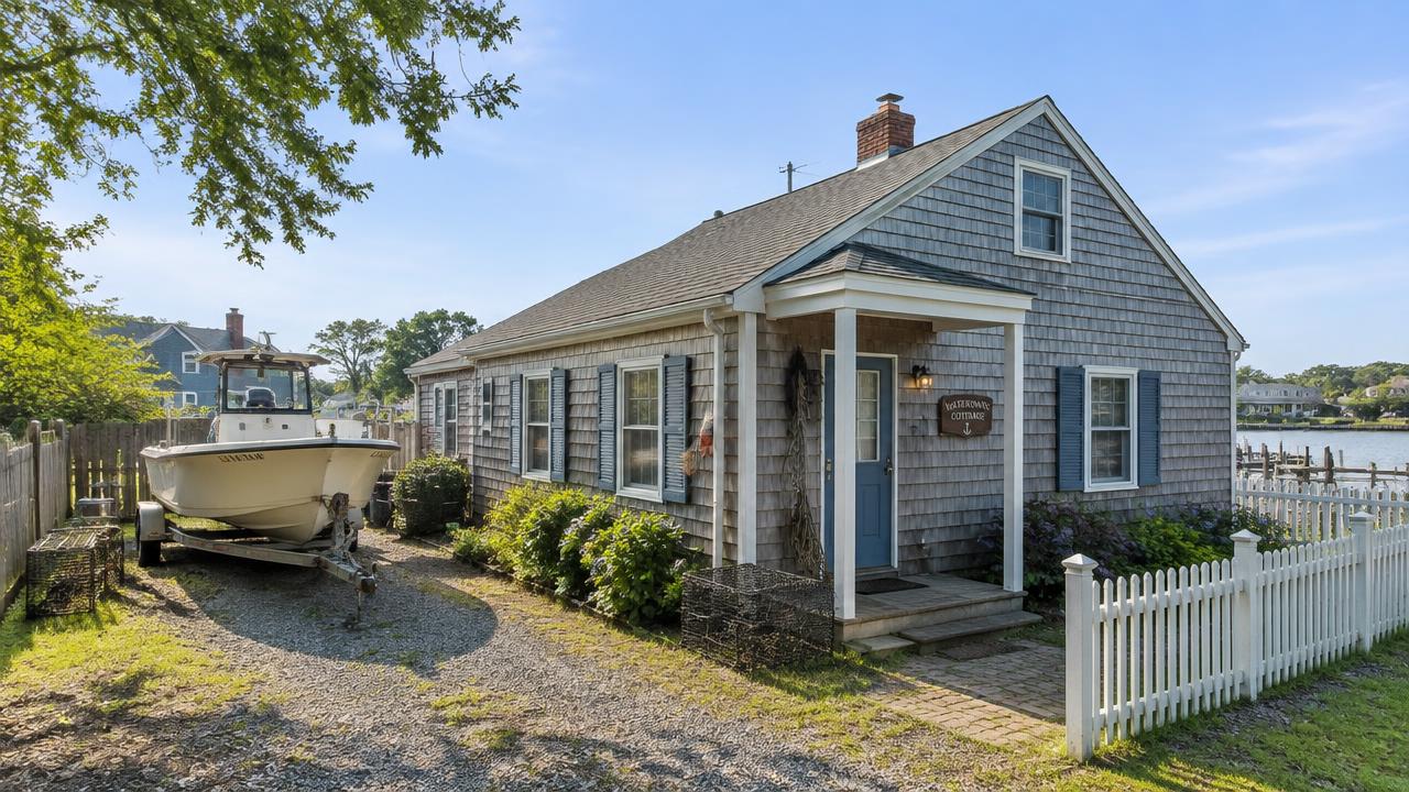 Waterman cottage with a workboat trailer in the side yard in Foxhill Road East, Hampton, Virginia