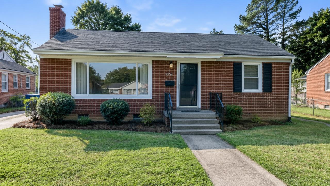 Post war brick home with a picture window and concrete steps in Swanson Homes, Portsmouth, Virginia